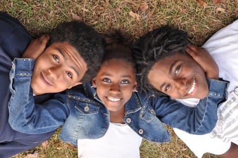 Qevonte and his siblings laying in the grass